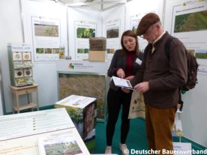 Besucher der Agritechnica informiert sich mit dem Maßnahmenbuch über Naturschutzmaßnahmen im Projekt "Lebendige Agrarlandschaften"